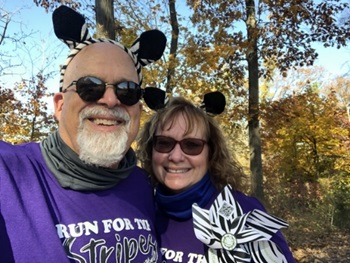 two people smiling with striped ears on their heads